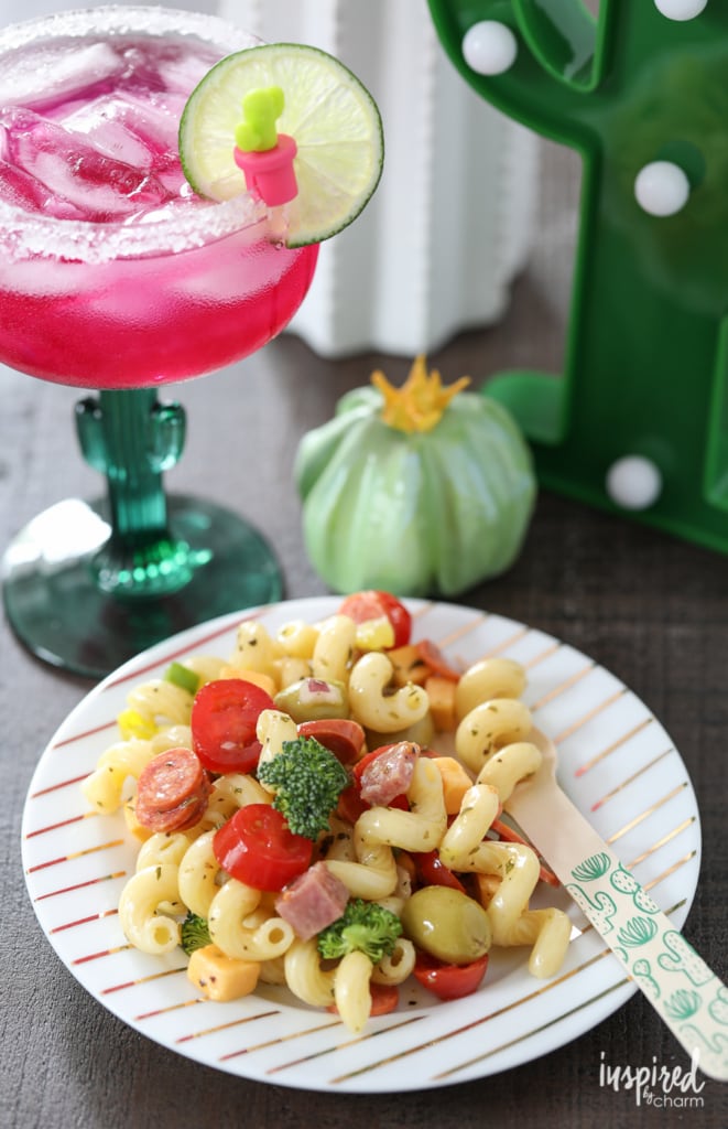 pasta salad served on a small plate next to a prickly pear margarita.