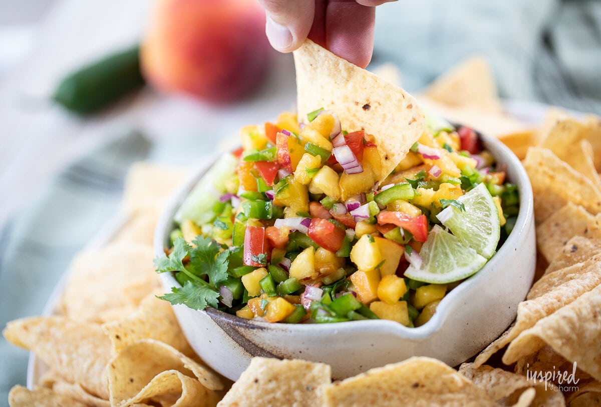 Spicy Peach Salsa in a bowl with tortilla chips.