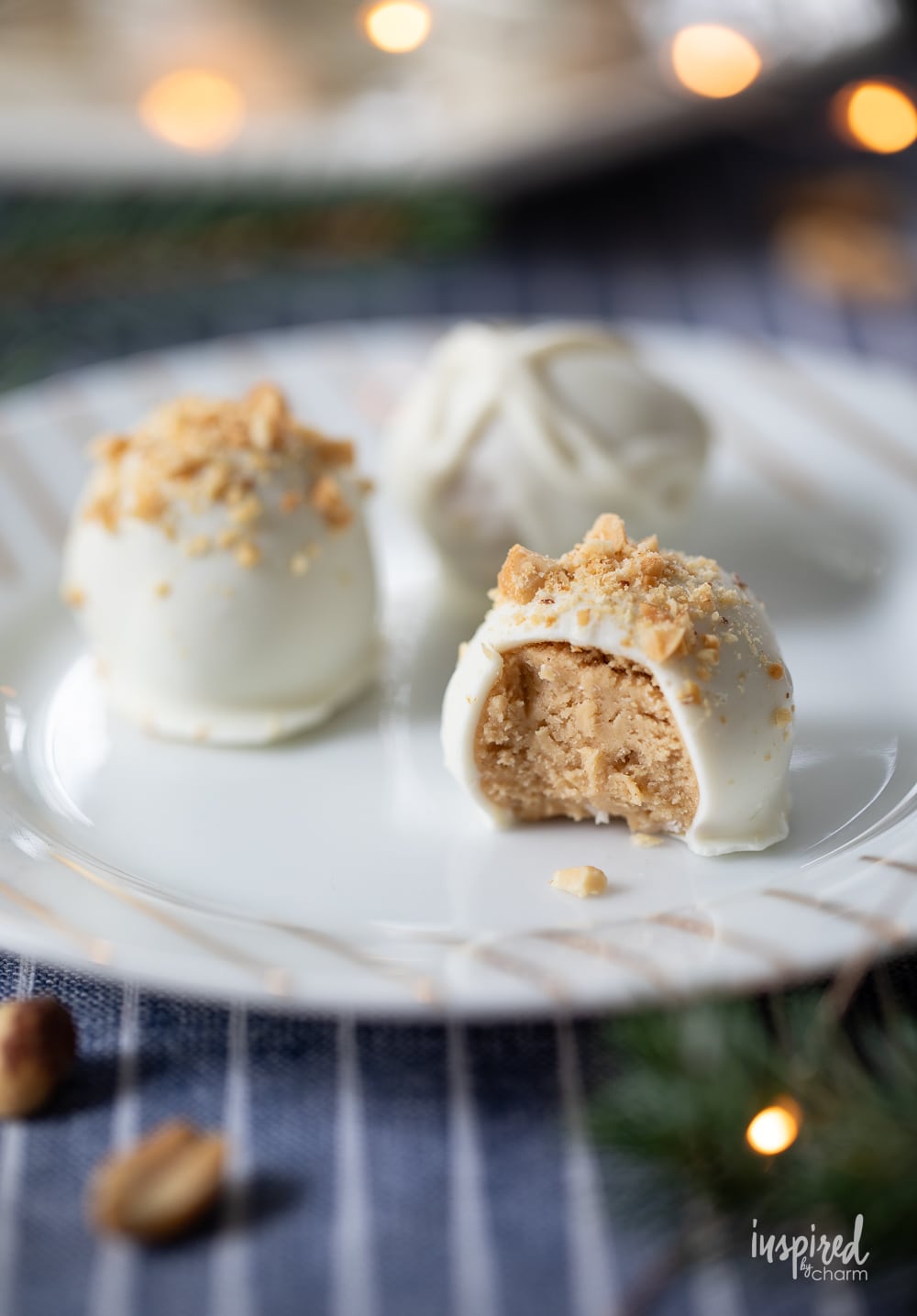 three peanut butter truffles on a plate with a bite taken out.