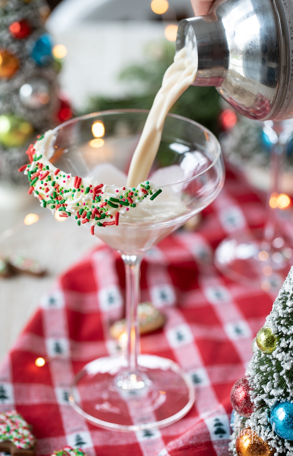 shaker pouring sugar cookie martini into a martini glass.