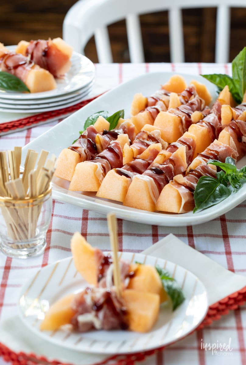 Prosciutto Melon Bites on white platter.