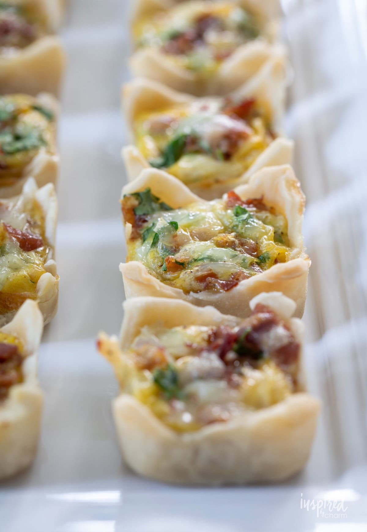 Prosciutto Arugula Mini Quiche served on a plate.