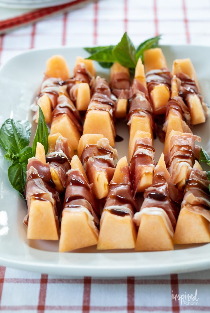 Prosciutto Melon Bites on white platter.