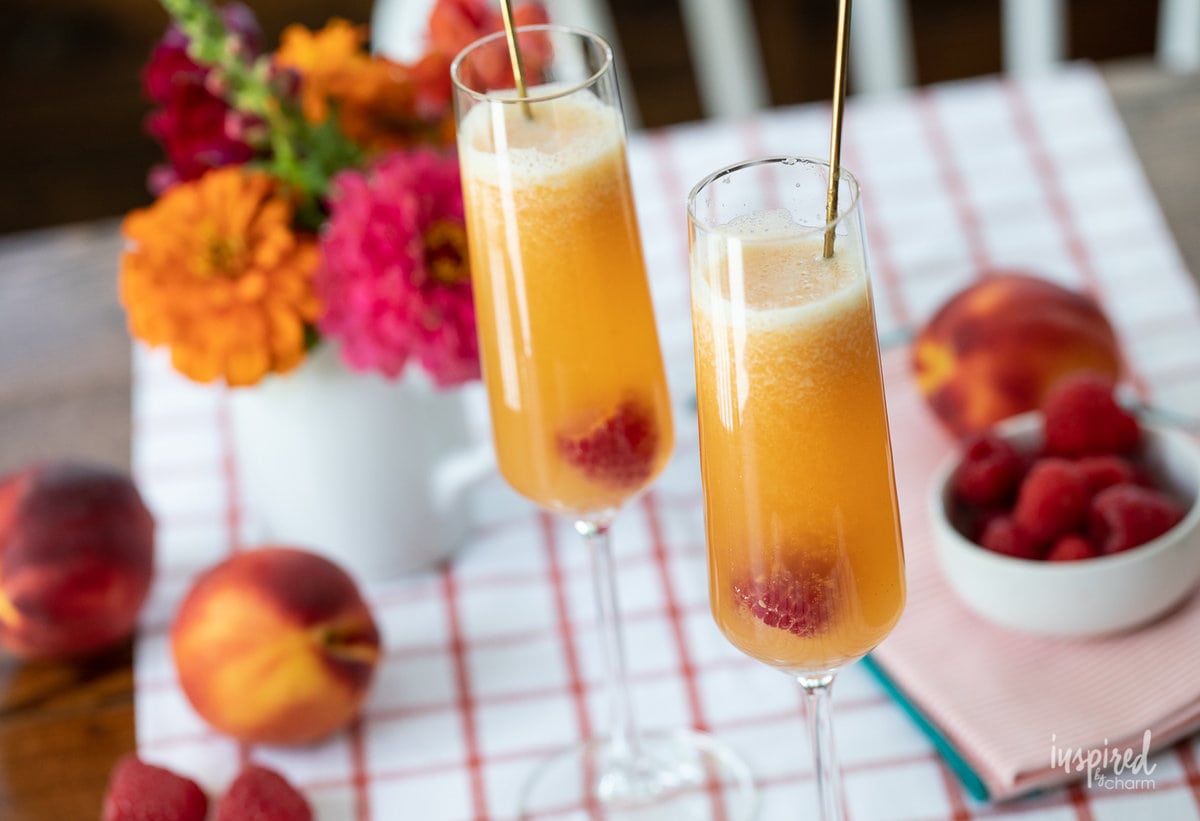 Raspberry Peach Bellinis in glasses on table.