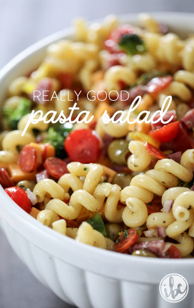 really good pasta salad in a large white bowl with text. 