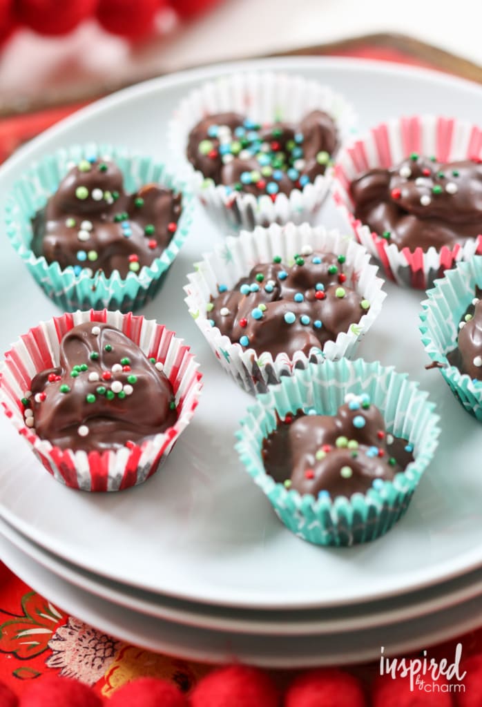 christmas candy in the crock pot served on a stack of white plates.