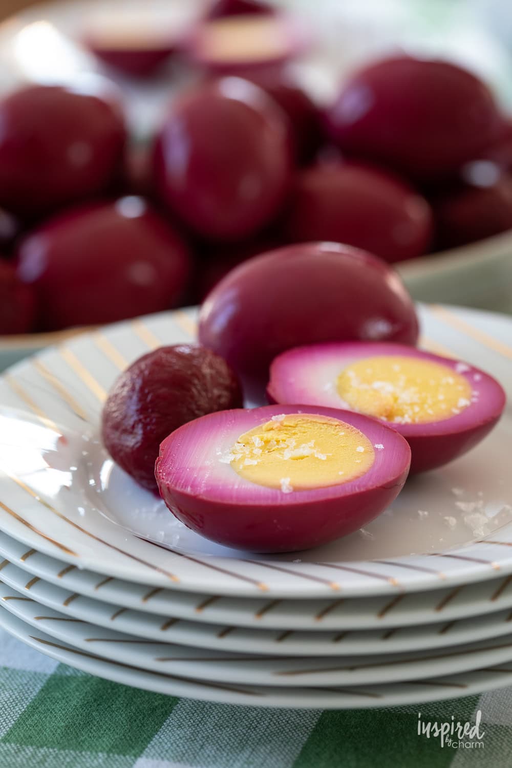 red beet pickled egg on a plate sliced in half.
