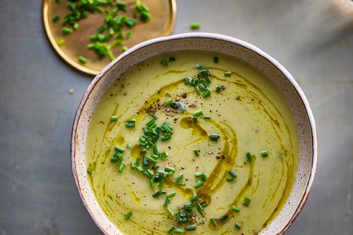 Bowl of roasted celery soup topped with olive oil and chopped chives