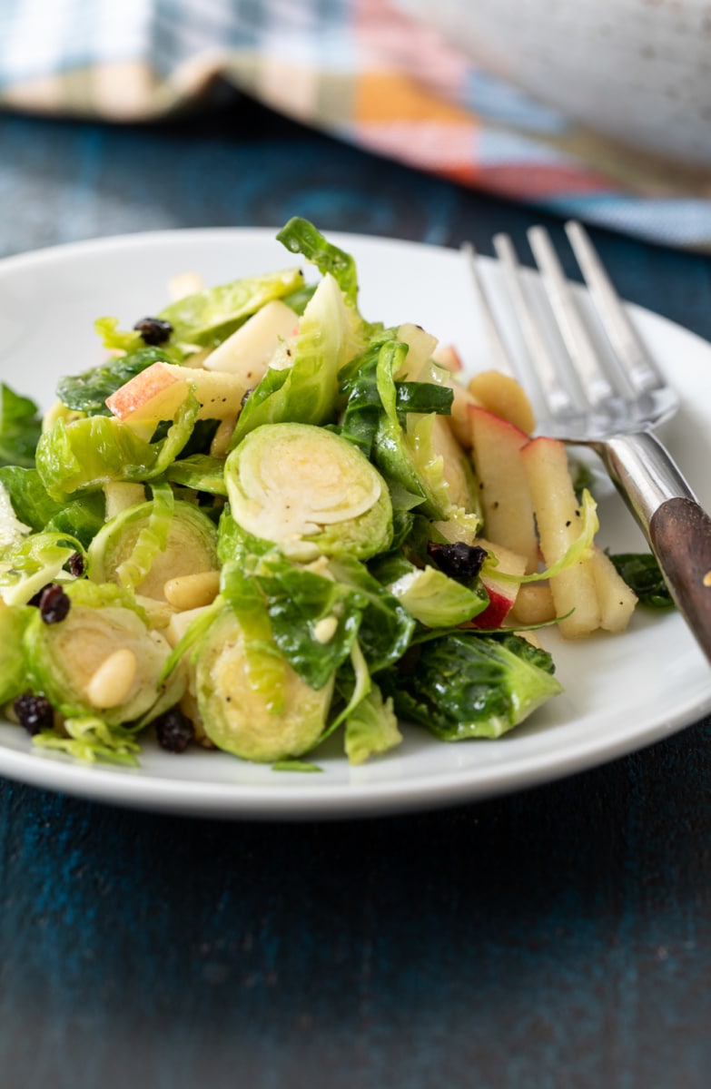 Shaved Brussels Sprout Salad served on a white plate.