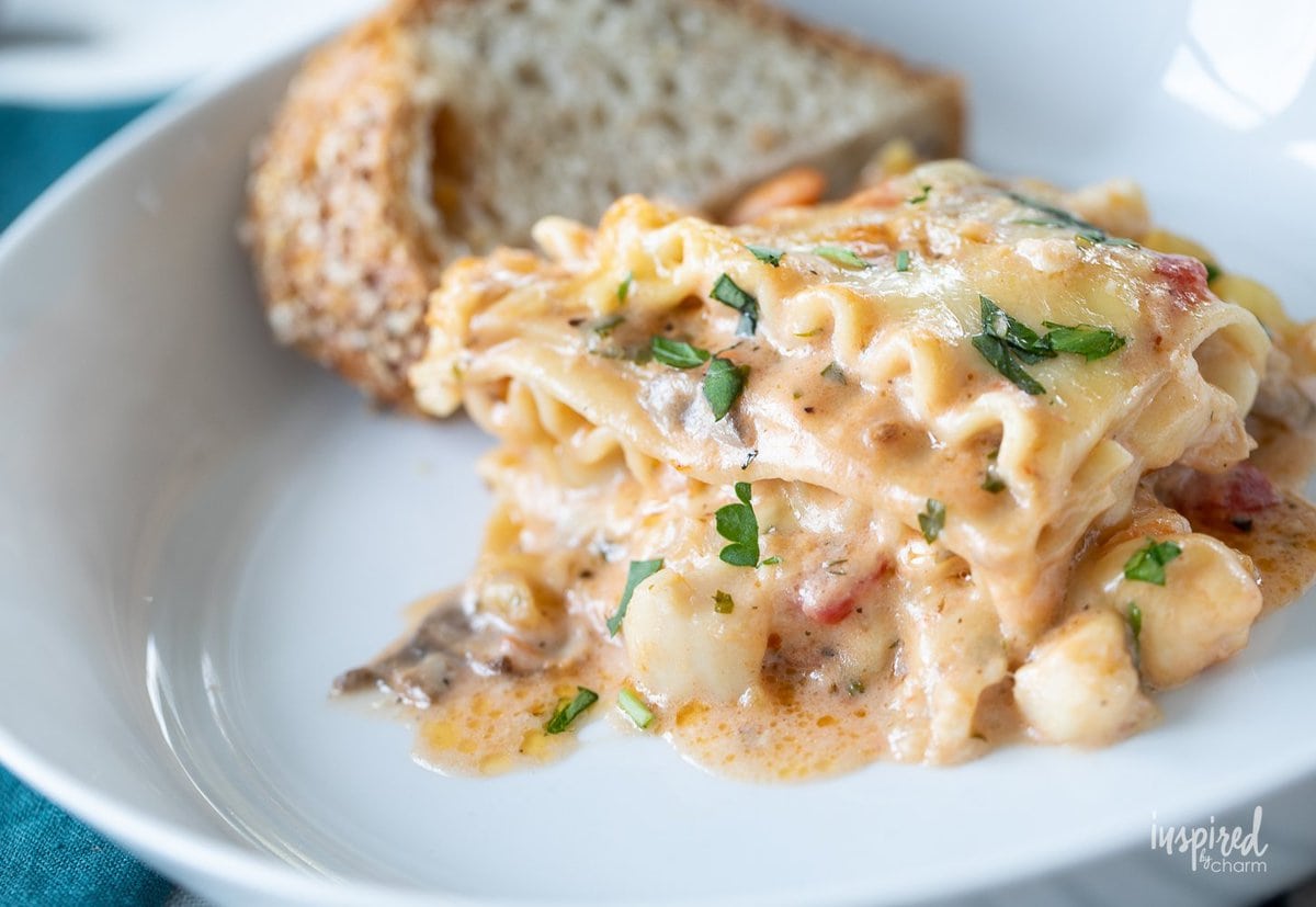 seafood lasagna on plate with bread.