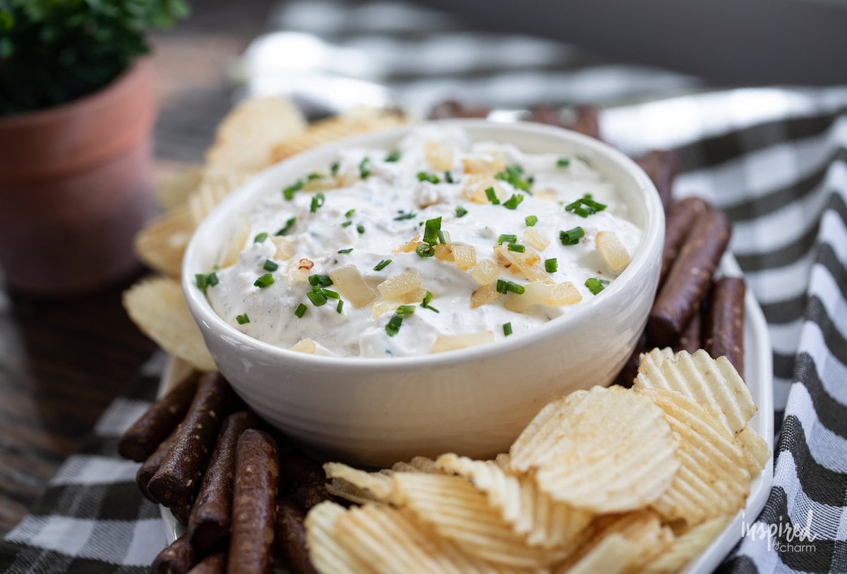 sour cream and onion dip in a bowl with potato chips and pretzels.