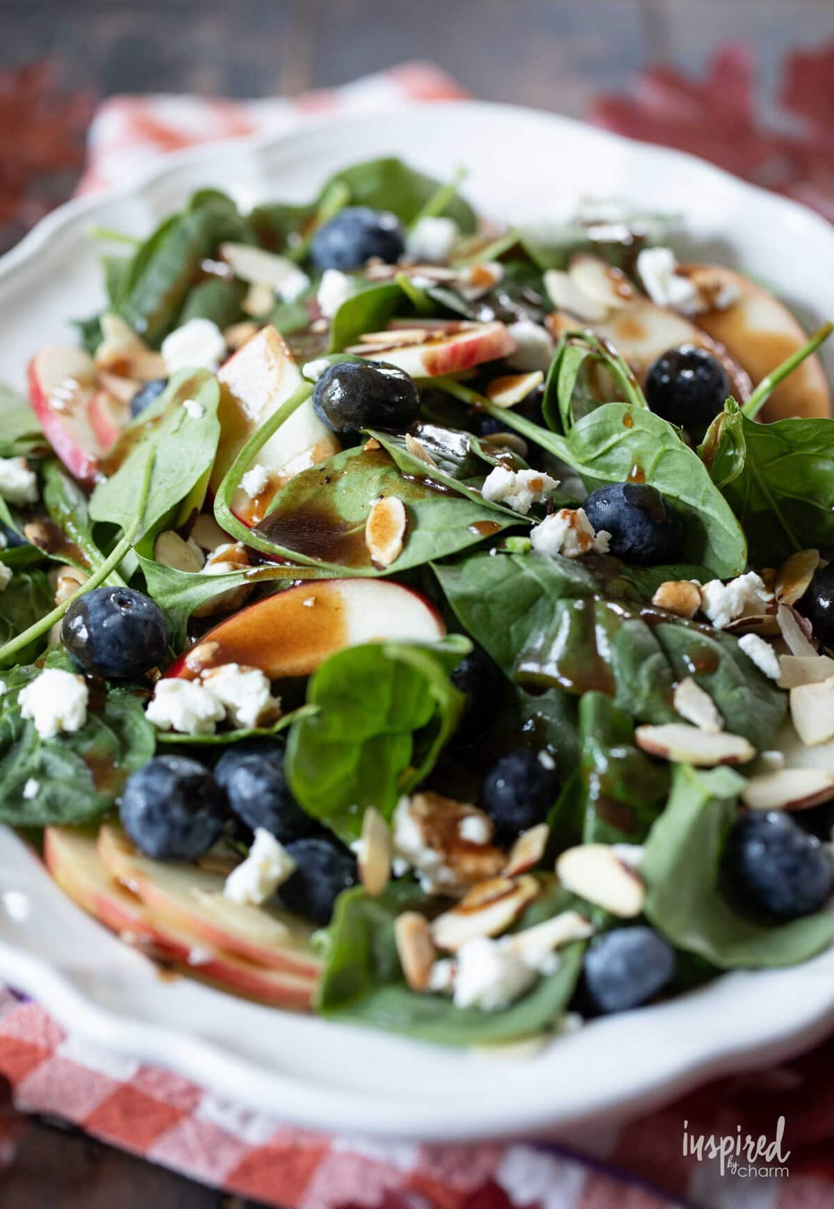 Spinach Salad Warm Maple Dressing served on a white plate.