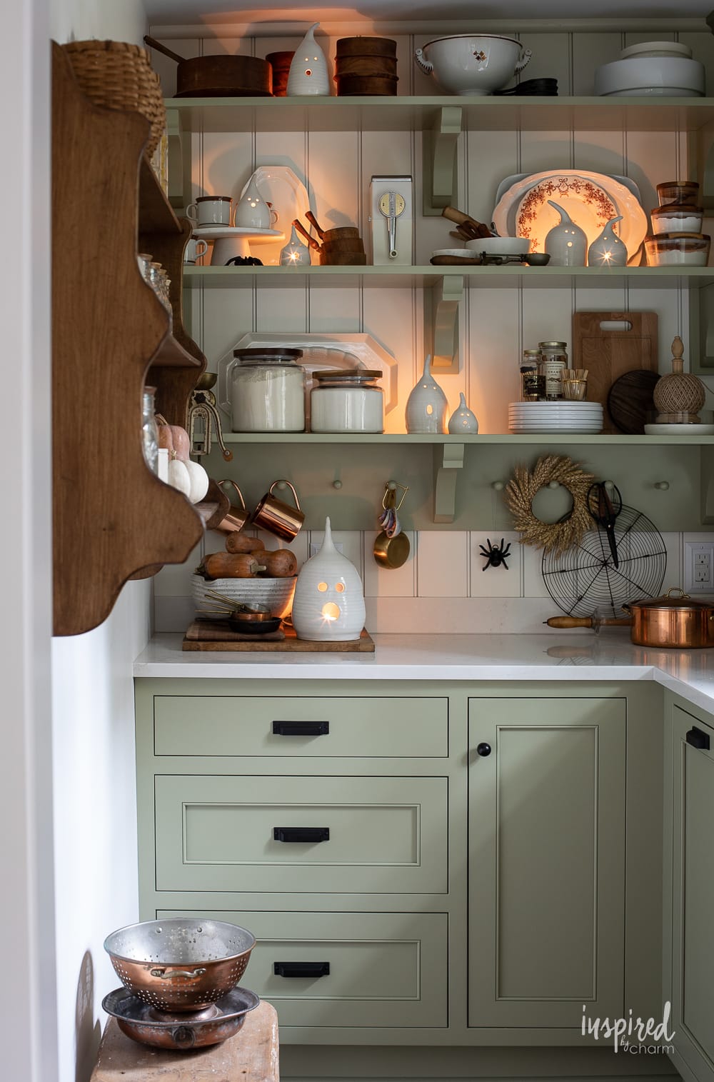 a butler's pantry decorated for fall with ghosts lanterns - cabinets are painted Sherwin-Williams sage.