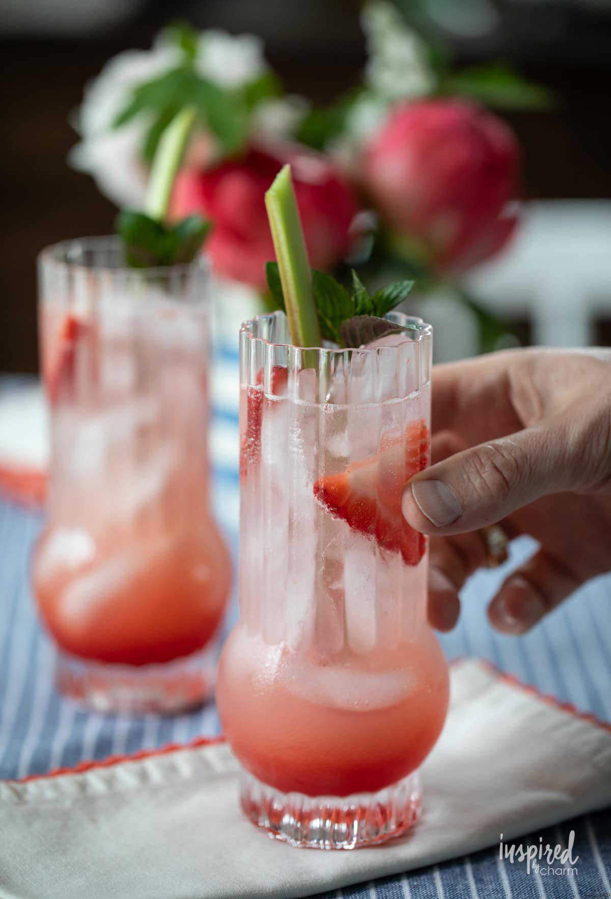 hand holding strawberry rhubarb spritz cocktail.