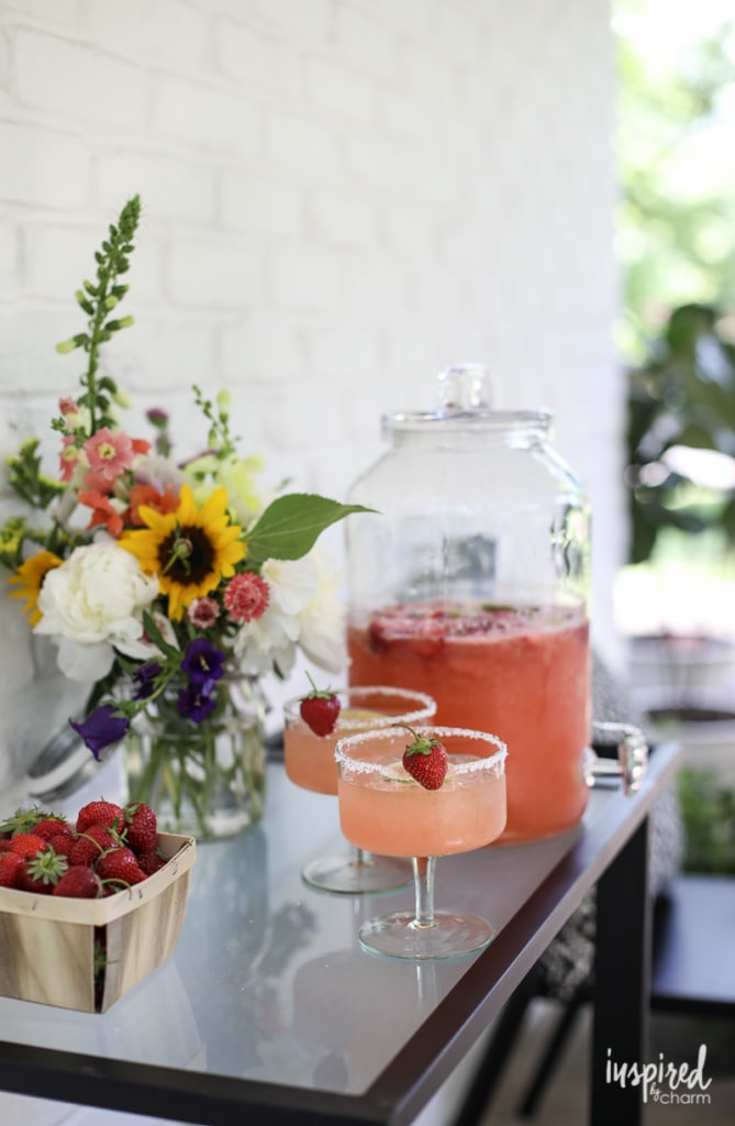 bar cart with Strawberry Margarita Punch in beverage dispenser and poured in glass.