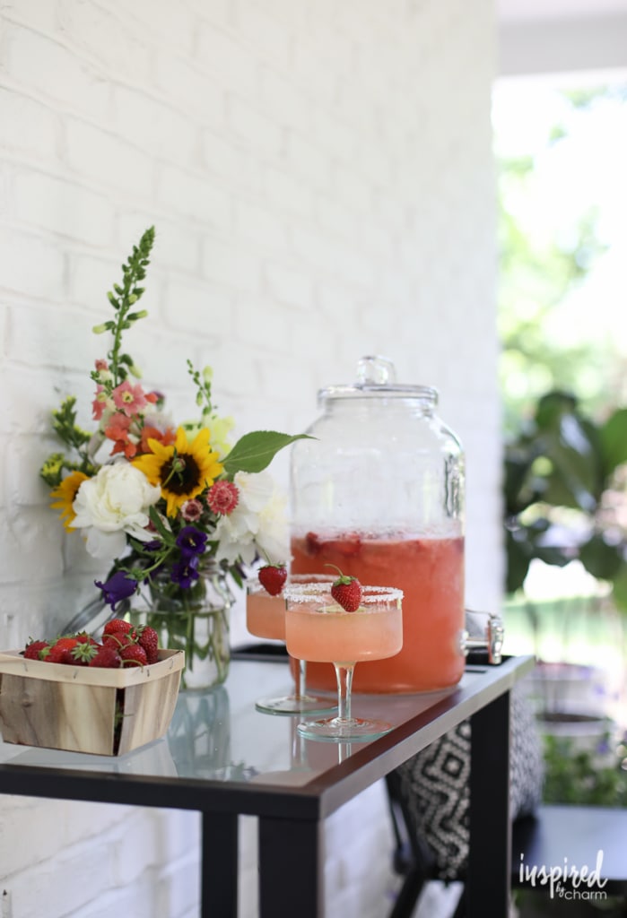 bar cart set up with Strawberry Margarita Punch and glasses.