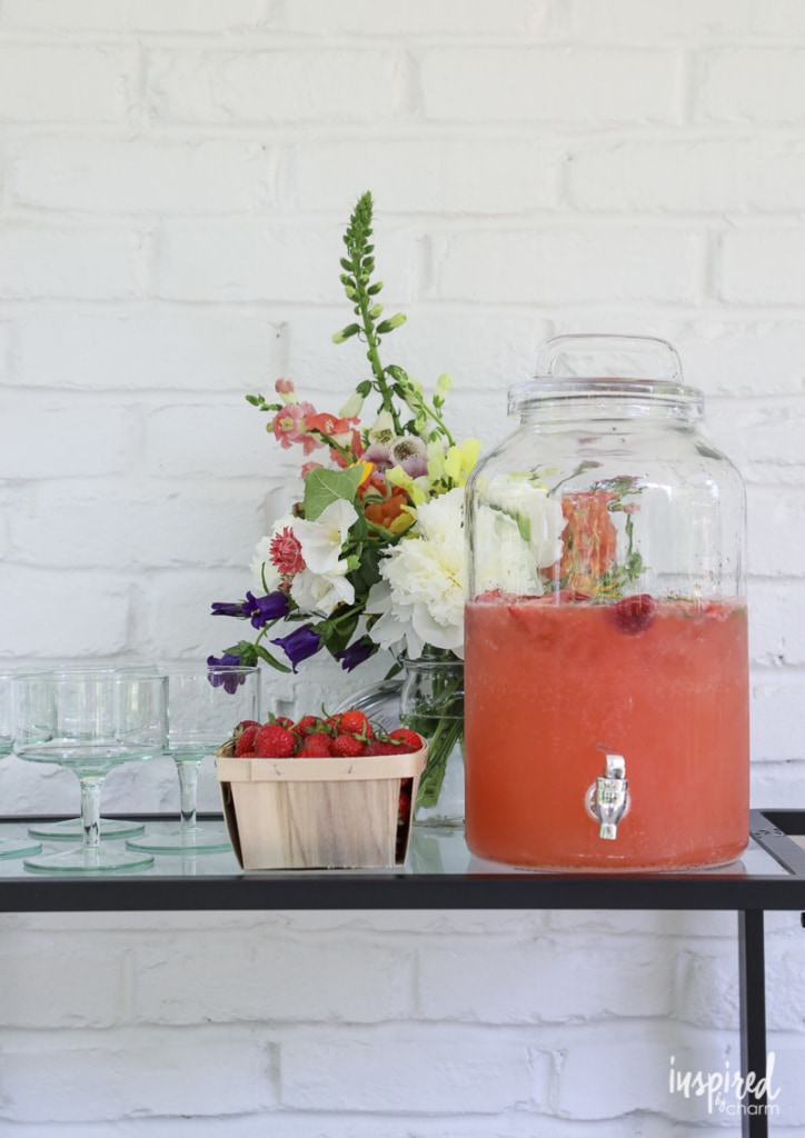 Strawberry Margarita Punch in beverage dispenser on bar cart.