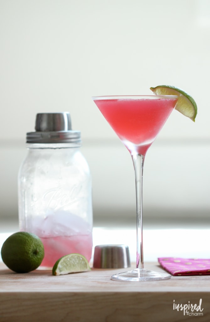 cosmopolitan in a long stem glass next to a shaker bottle