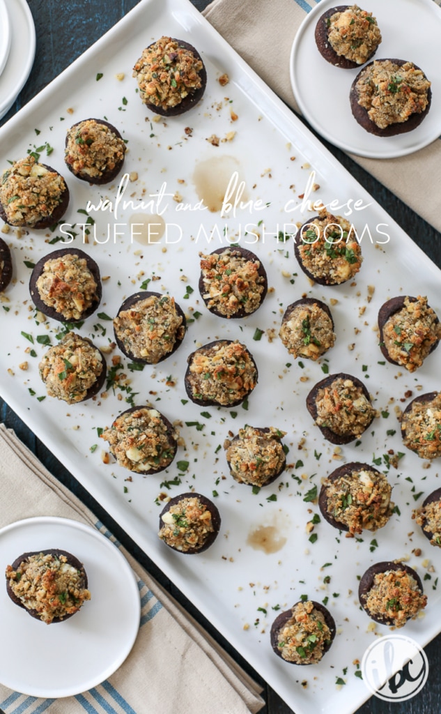 large platter of Walnut and Blue Cheese-Stuffed Mushrooms with some served on small plates.