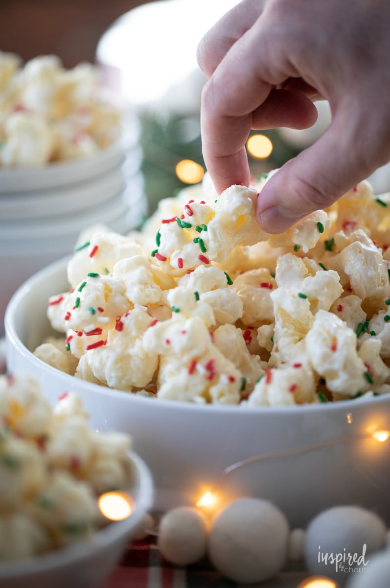 hand grabbing White Chocolate Puff Corn with sprinkles.