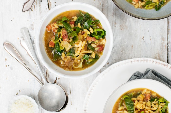 Four bowls of minestrone soup, with pasta and bacon