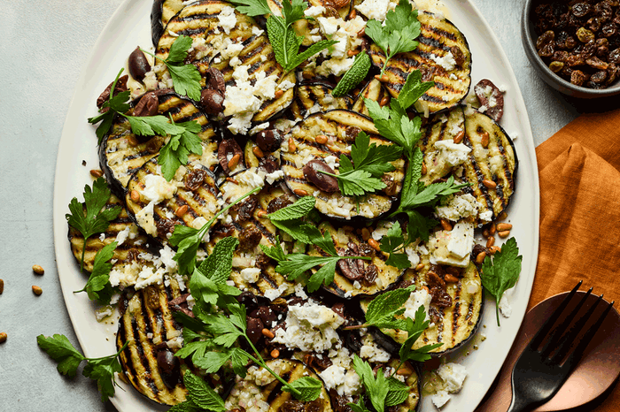 Large white serving plate with aubergine, mint & pine nut salad